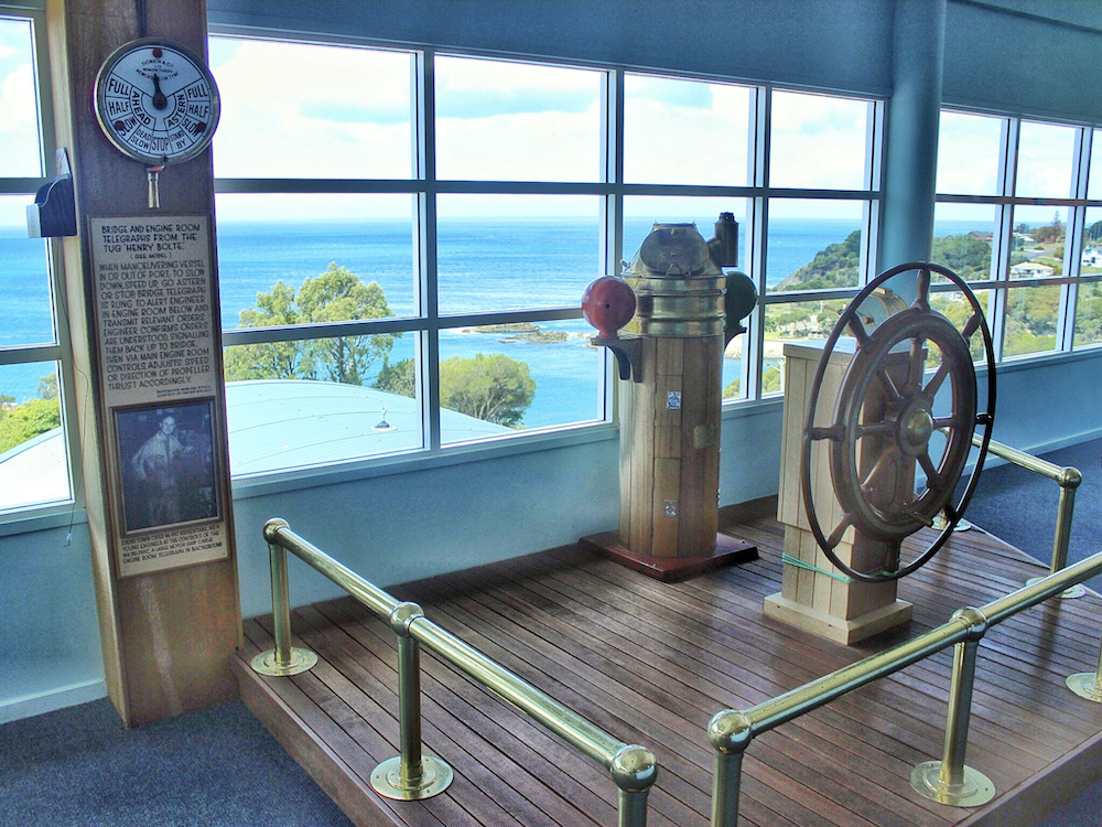 Mock ship's wheel on wooden platform in museum