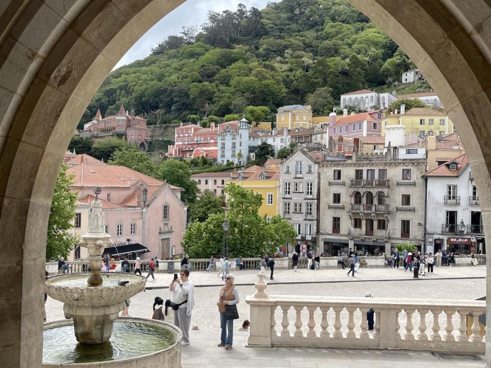 Colorful facades of buildings in Sintra Portugal framed by an arched doorway, seen during a day trip to Sintra.