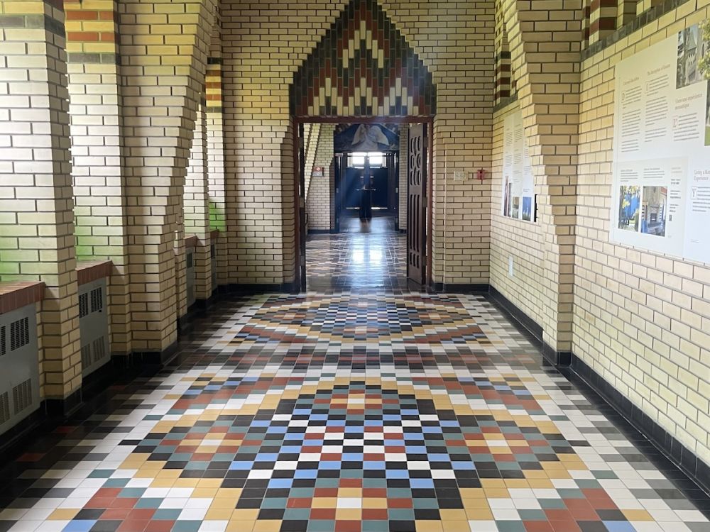Patterend tiles in brown, blue, yellow, red, white, and black decorate the floor of the hallway in the benedictine abbey.